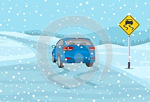 Safety car driving at winter season. Blue suv car is reaching the icy road. Slippery, wet roadway warning sign.