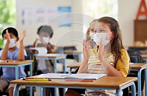 Safety, compliance and education in classroom at school with students wearing masks during corona pandemic. Young