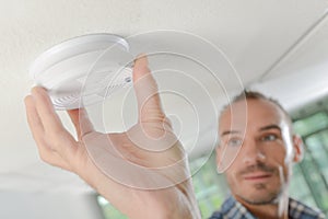 Safety conscious man fitting fire smoke alarm