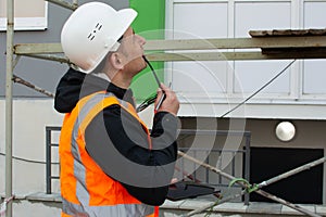 Safety engineer inspects the scaffolding on the construction site. Obtaining access to construction work.