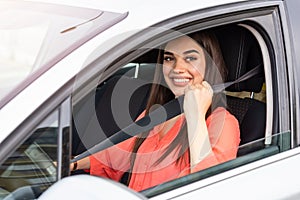 Safety first. Beautiful Caucasian lady fastening car seat belt. Pretty young woman driving her new car. Pretty young woman driving