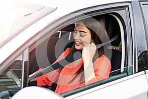 Safety first. Beautiful Caucasian lady fastening car seat belt. Pretty young woman driving her new car. Pretty young woman driving