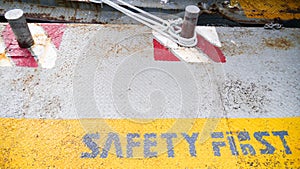 Safety first yellow label floor sign symbol on grey metal texture