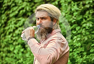 Safety and health. Water balance. Man bearded tourist drinking water plastic bottle nature background. Thirsty guy