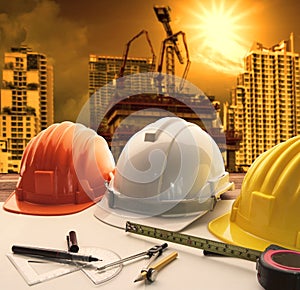 Safety helmet on architect ,engineer working table with modern b