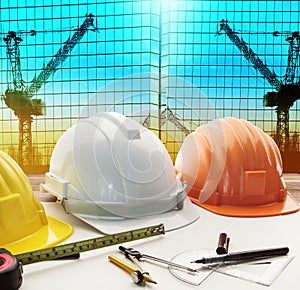 Safety helmet on architect ,engineer working table with modern b