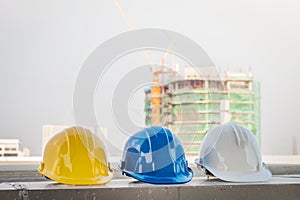 The safety helmet and the blueprint at construction site with crane background