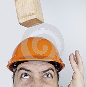 Safety helmet. Brick and a board fall on builder head. Saving a life due to wearing a protective construction helmet. Protection