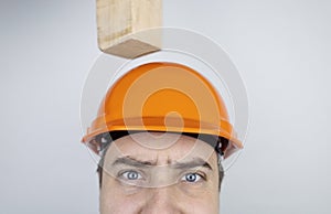 Safety helmet. Brick and a board fall on builder head. Saving a life due to wearing a protective construction helmet. Protection