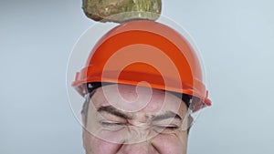 Safety helmet. Brick and a board fall on builder head. Saving a life due to wearing a protective construction helmet. Protection o
