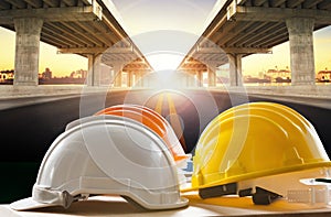 Safety helmet on civil engineering working table against bridge