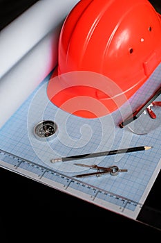 safety helmet compasses compass paper sketches and goggles on engineer's desktop