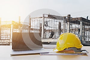 safety helmet and computer laptop on table in concstruction