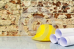 Safety helmet and drawings project on brick wall background