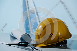 Safety helmet hat and projects of construction site building on a table. Building concept. Safety first