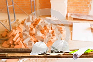 Safety helmet plastic and blueprint on wood with blur construction building site workplace background. with copy space add text