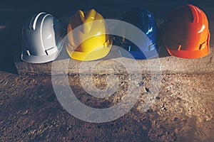 Safety helmet, white, yellow, blue and orange, placed on the cement floor in the construction site