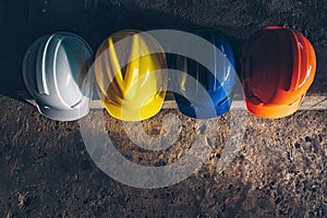 Safety helmet, white, yellow, blue and orange, placed on the cement floor in the construction site