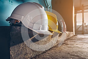Safety helmet, white, yellow, blue and orange, placed on the cement floor in the construction site