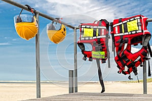 Safety helmets and life jackets hanging on railing