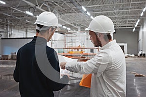 Safety inspector and build worker inside building under construction