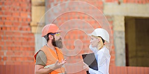 Safety inspector concept. Construction site safety inspection. Discuss progress project. Woman inspector and bearded