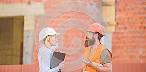 Safety inspector concept. Construction site safety inspection. Discuss progress project. Woman inspector and bearded
