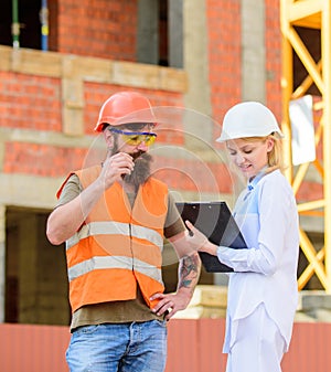 Safety inspector concept. Discuss progress project. Inspector and bearded brutal builder discuss construction progress