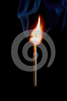 Safety match on black background with flaming head