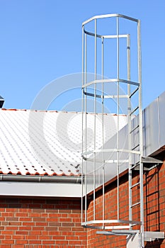 Safety metal ladder to the roof and blue sky