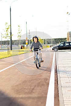 Safety in a modern European city. little happy boy rides a bike on a secure rubberized bike path