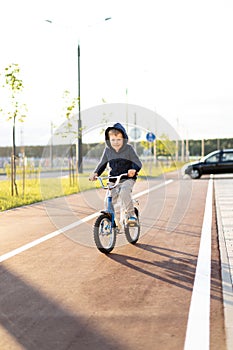 Safety in a modern European city. little happy boy rides a bike on a secure rubberized bike path