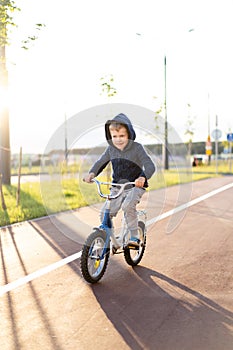 Safety in a modern European city. little happy boy rides a bike on a secure rubberized bike path