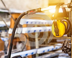 Safety noise at the workplace, yellow headphones against noise hang in the workshop for the manufacture of PVC windows