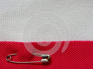 Safety pin on fabric background with note space