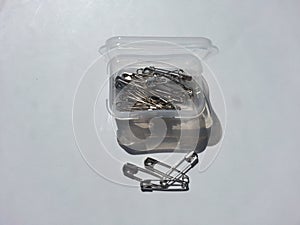 Safety pin plastic container on white background