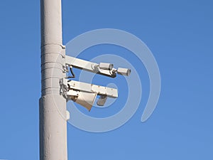 Safety road traffic cameras mounted on the pole against clear blue cloudless sky