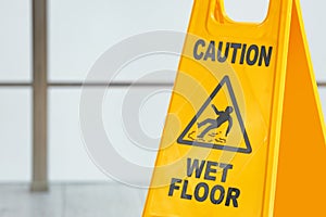 Safety sign with phrase Caution wet floo