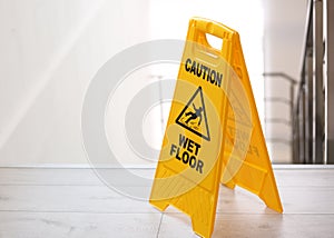 Safety sign with phrase Caution wet floor