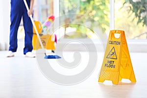 Safety sign with phrase Caution wet floor