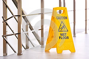 Safety sign with phrase Caution wet floor, indoors