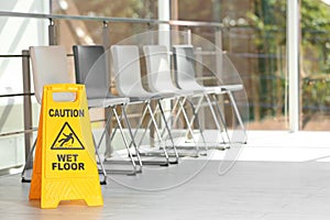 Safety sign with phrase Caution wet floor, indoors