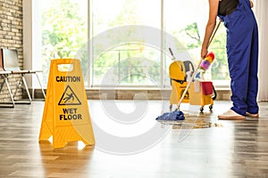 Safety sign with phrase Caution wet floor photo