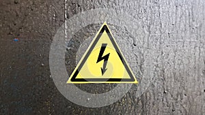 Safety sign yellow and black on a silver metal background. High voltage lightning in a triangle caution caution danger electricity