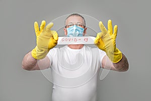 Safety virus infection concept. Man in protective suit and antigas mask with glasses. holding a sheet with the words