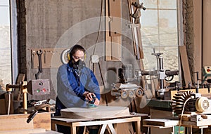 Safety in woodworking. Female carpenter in googles and dust mask