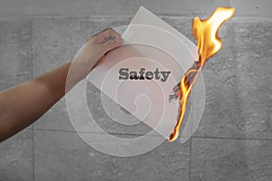 Safety word text on fire with burning paper