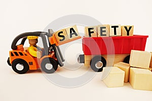 Safety at work concept with orange forklift with wooden blocks on white background