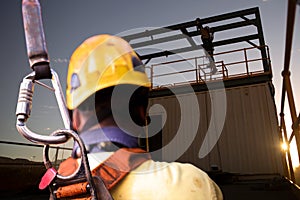 Safety workplace construction worker wearing yellow safety helmet fall arrest PPE harness attached an inertia reel shock absorber photo
