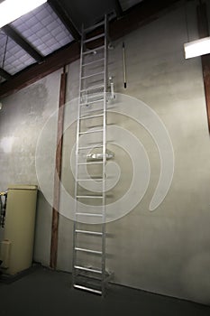 Safety workplace industrial Aluminium safety ladder installed on the vertical interior concrete wall